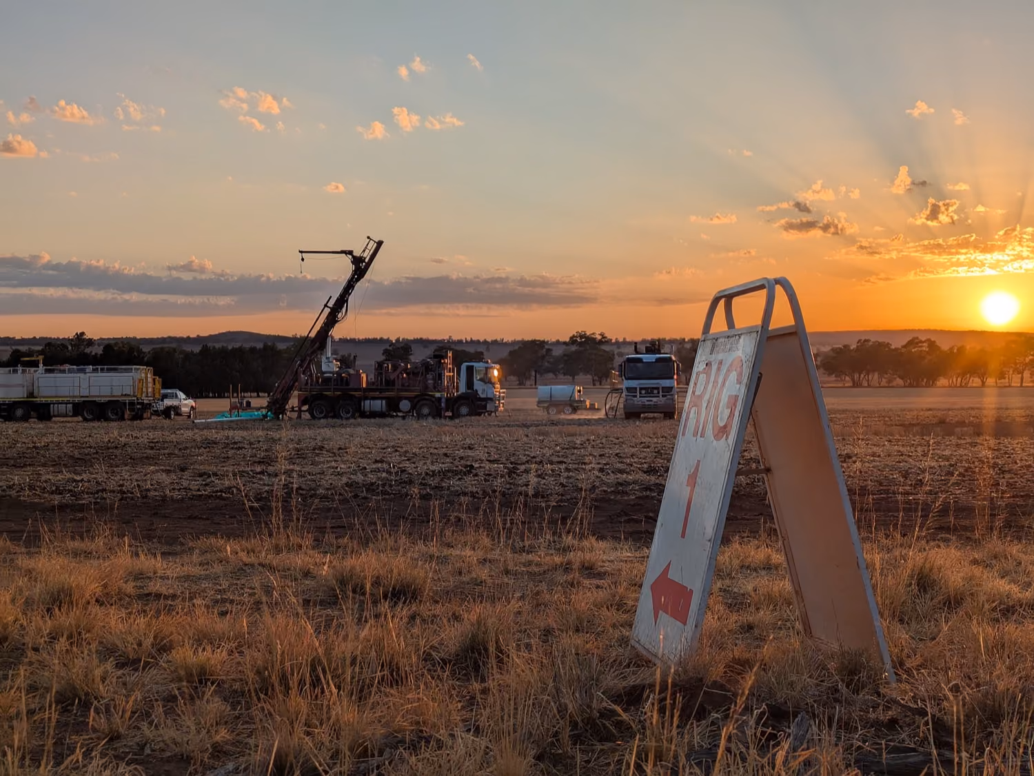 Exploration drilling rig operating on site at sunset