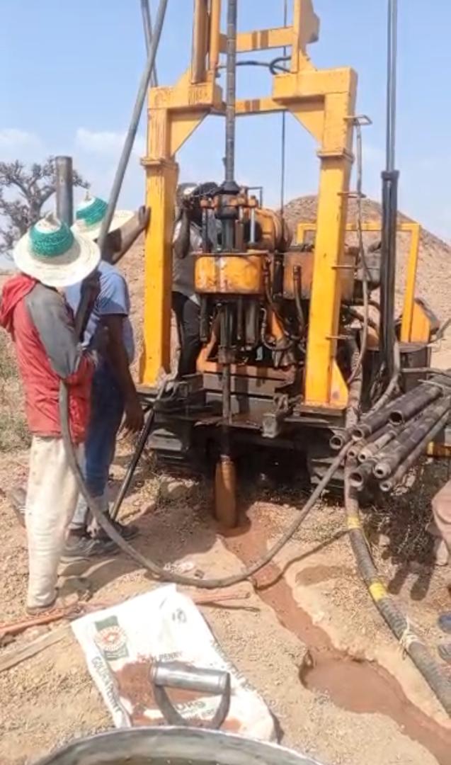 Portable drill rig in operation, advancing a borehole at the survey site.